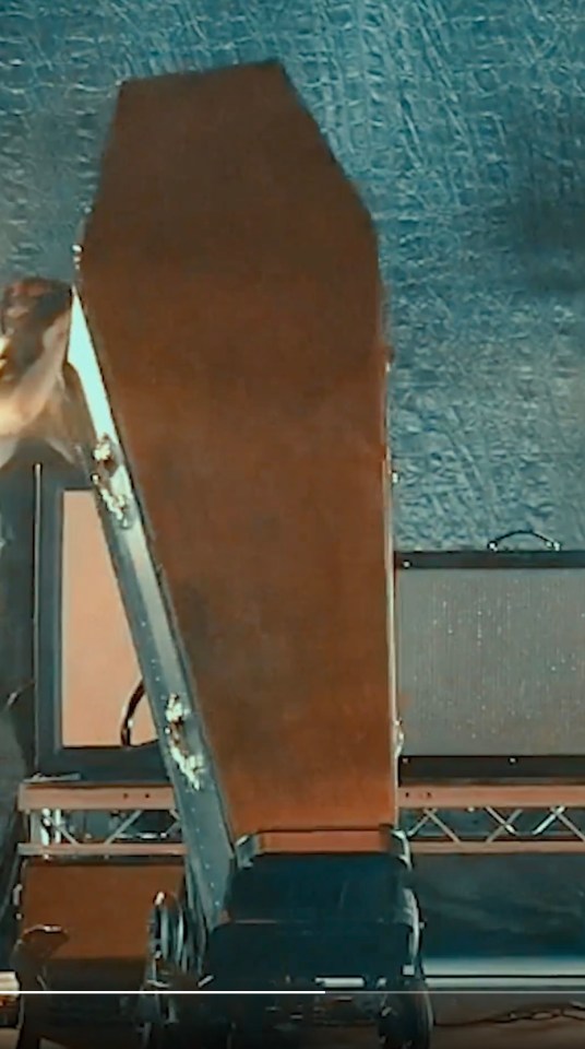 Iggy Pop being carried off stage in a coffin.