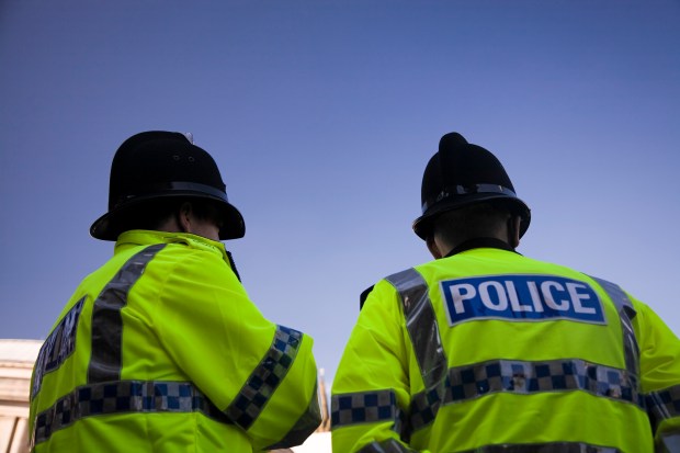 Two British police officers from behind.