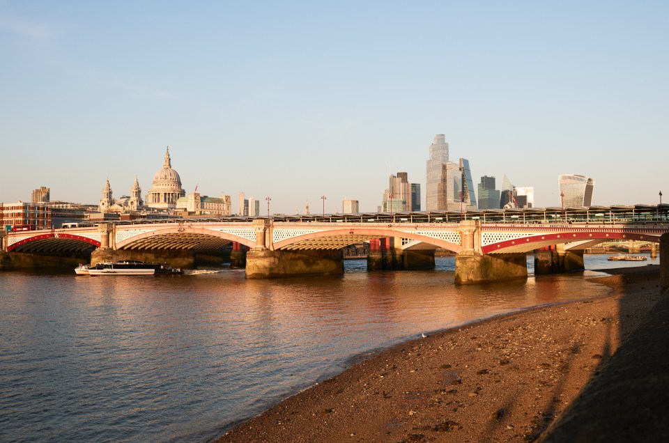 Blackfriars Bridge over the River Thames in London, with St. Paul's Cathedral and the city skyline in the background.