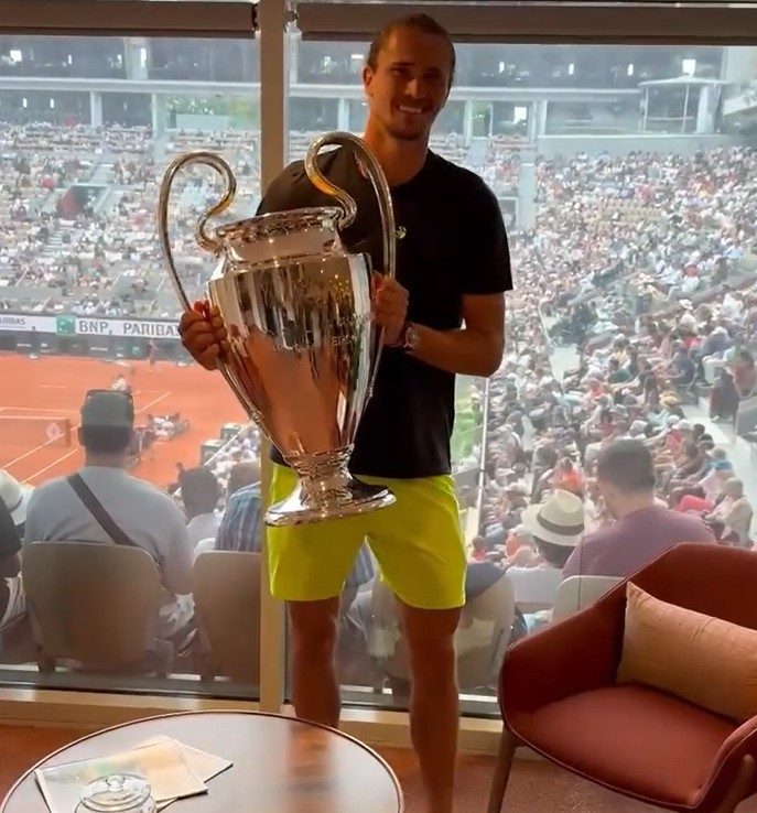 Alexander Zverev holding the Champions League trophy.